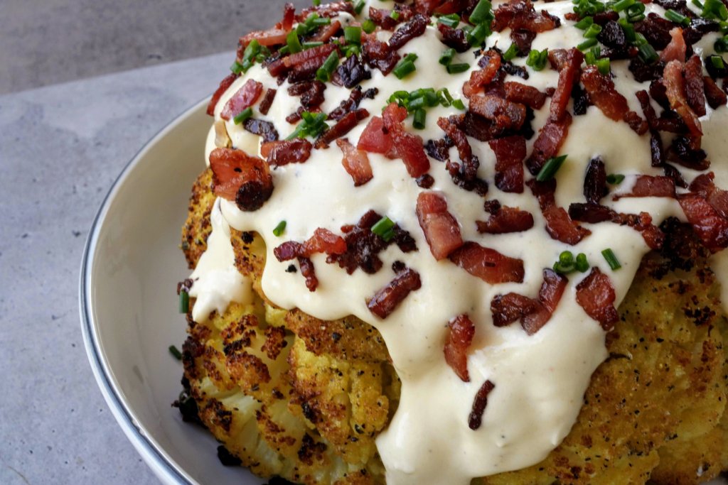 Loaded Cauliflower is the perfect low carb substitute for a loaded potato. This cauliflower is roasted whole & topped with cheese sauce, bacon and chives.