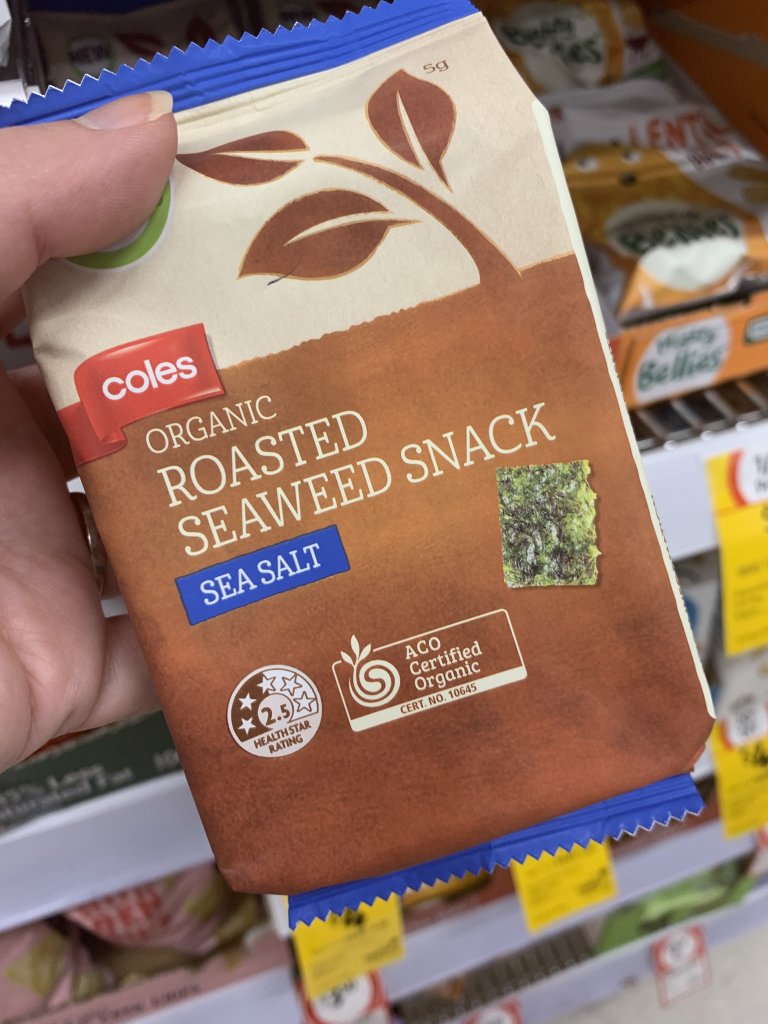 Hand holding Coles roasted seaweed snack. A perfect keto snack at Coles. 