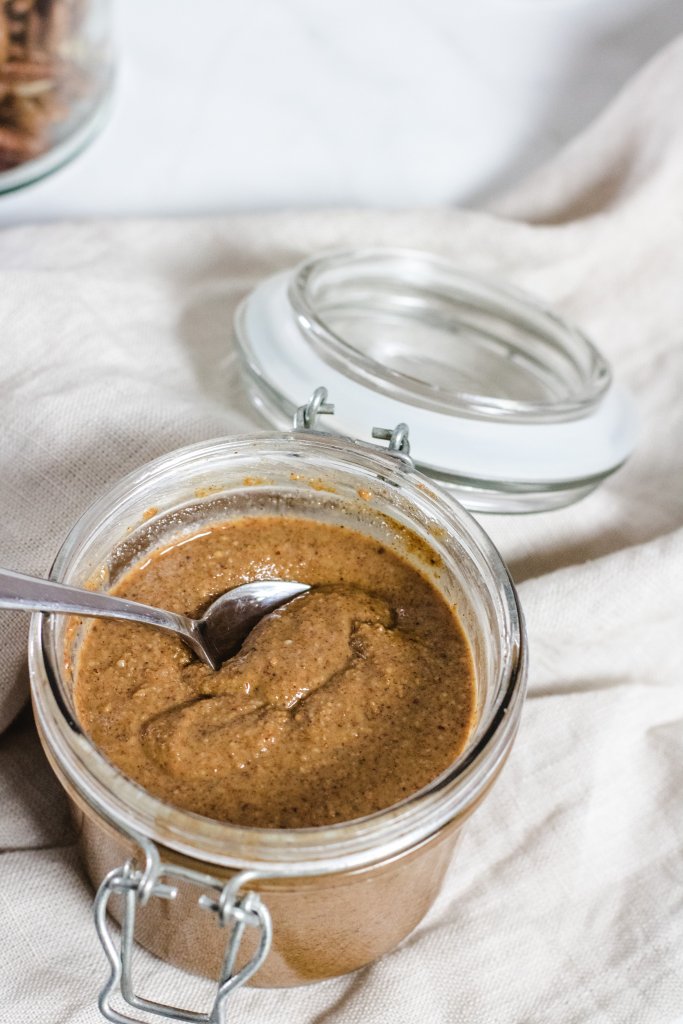 Jar of almond butter with a spoon, spooning some out" 