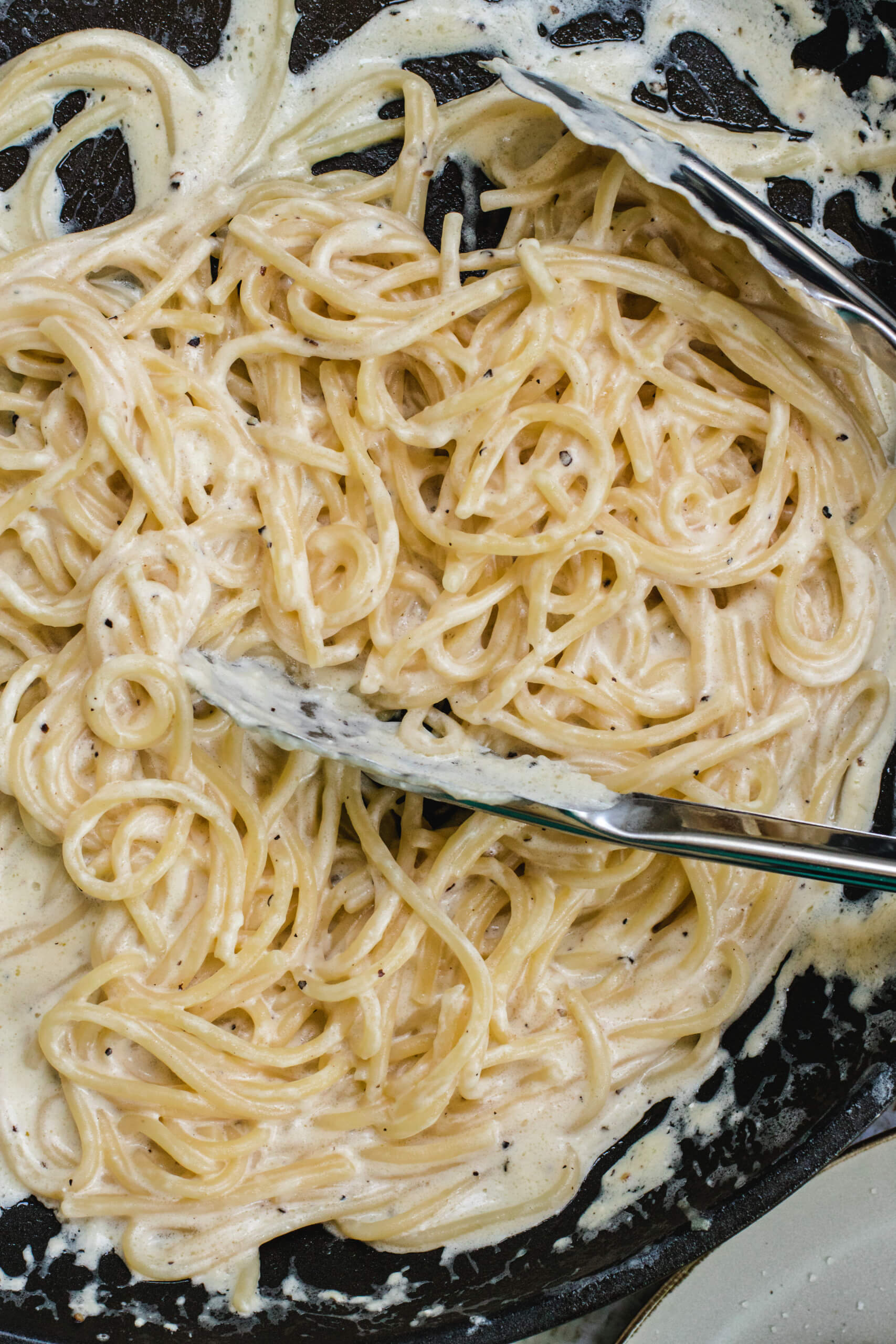 Cream cheese pasta with silver tongs