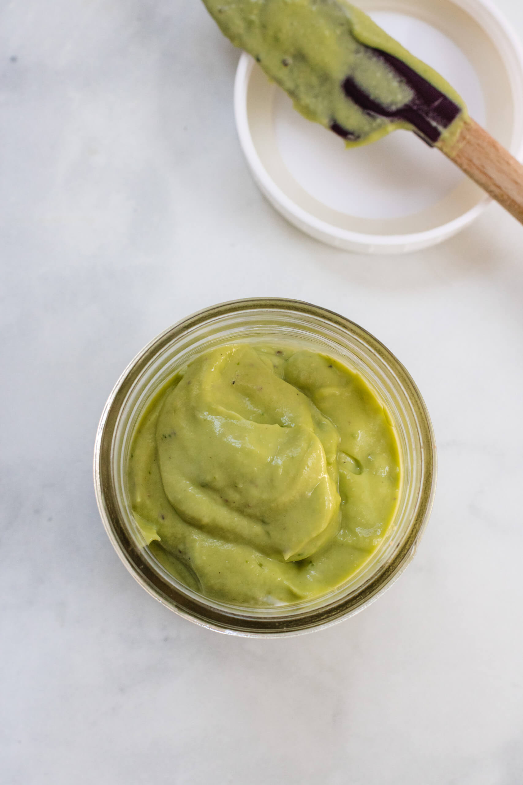 Top view of avocado lime dressing in a glass jar. 