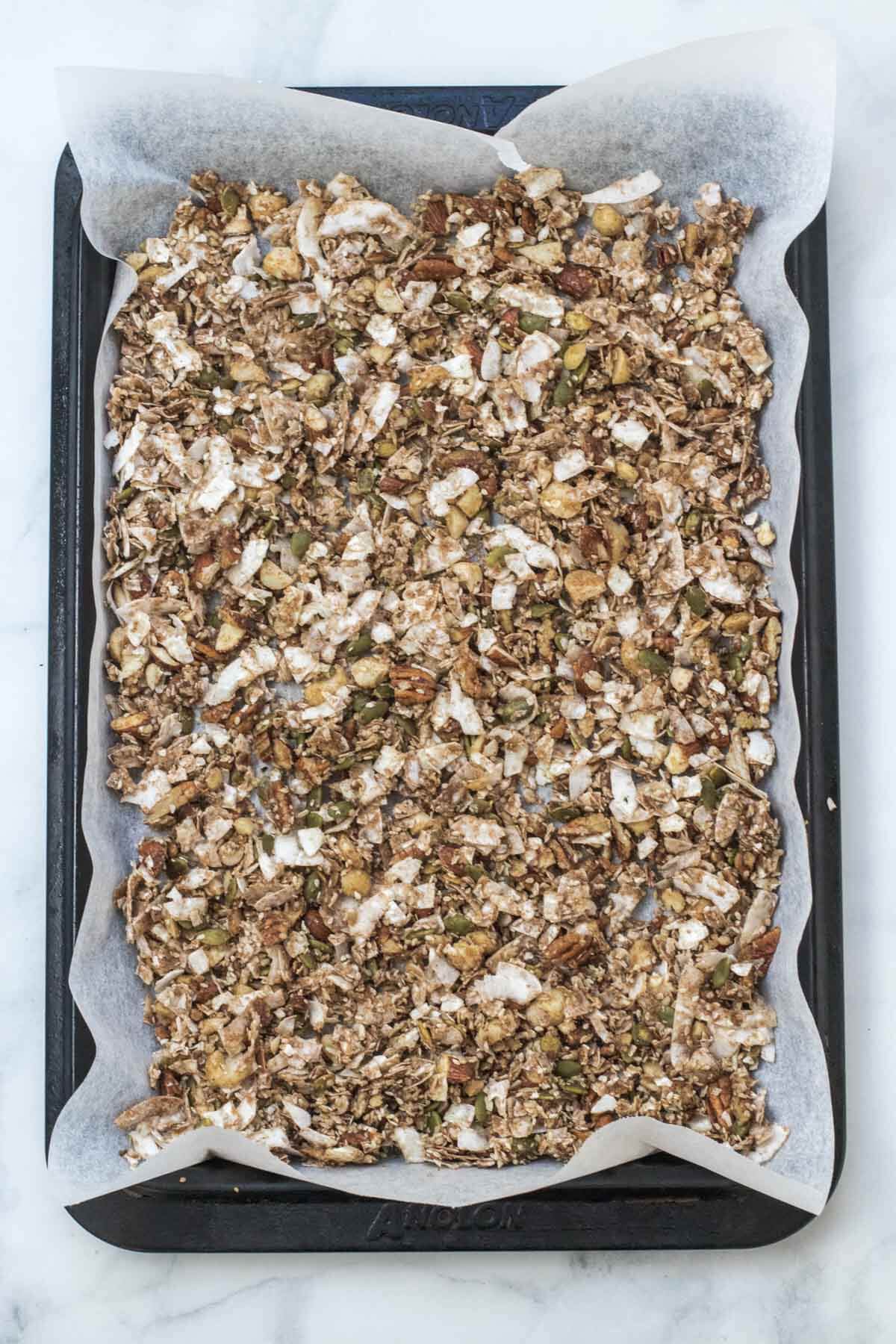 A lined tray of granola ready to go in the oven.