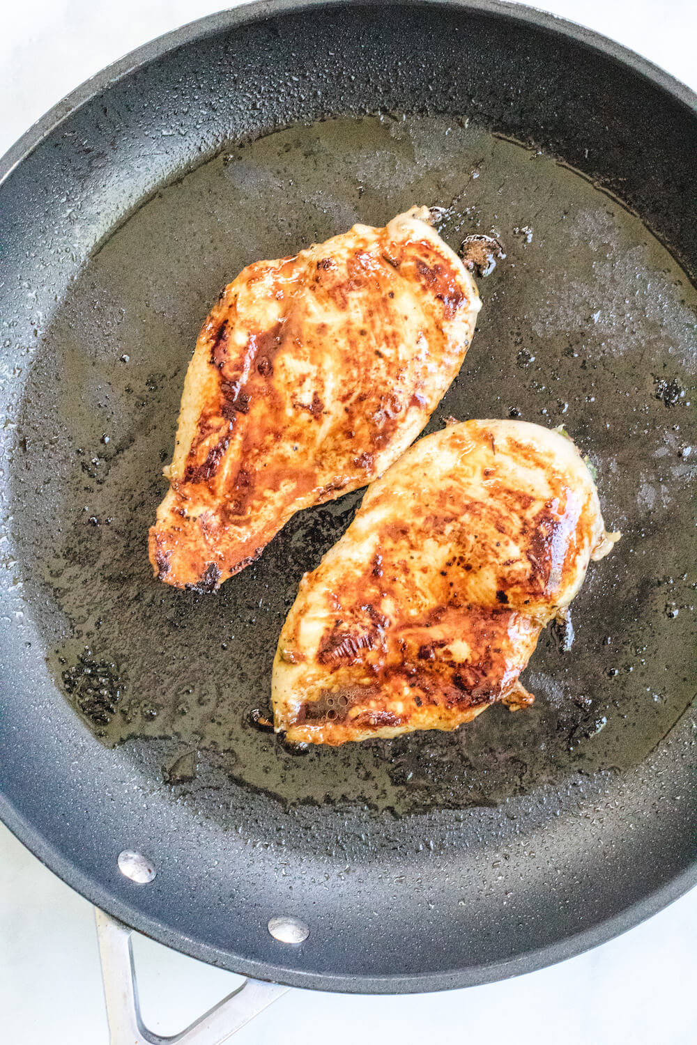 Grilled chicken pieces in a skillet.